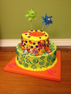 a brightly colored birthday cake with decorations on top