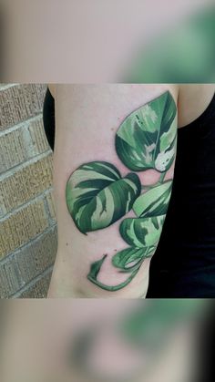 a woman with a green leaf tattoo on her arm