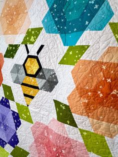 a colorful quilt with a bee on it