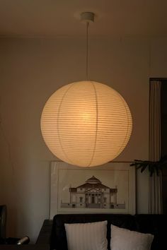 a living room filled with furniture and a large white light hanging over it's head