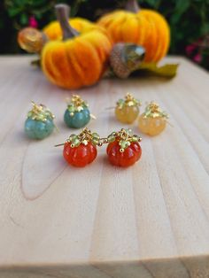 These cute carved pumpkin earrings come in a variety of colors including orange, blue, and yellow. Accented with peridot to represent the leaves and hooked onto surgical steel ear wires.  Choose from either gold or silver! Please note each pair will be a unique color due to natural stone variations.  Packaged in a jewelry box and shipped in an eco friendly mailer. Stone Pumpkin, Pumpkin Jewelry, Autumn Earrings, Orange Jewelry, Carved Pumpkin, Pumpkin Earrings, Carved Stone, Fall Earrings, Mini Pumpkins