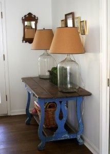 a table with two lamps on top of it next to a mirror and lamp shade