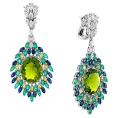 Geraldo Emerald Sapphire Diamond Peacock Earrings - A Captivating Celebration of Elegance and Beauty Embrace the mesmerizing beauty of the Geraldo Emerald Sapphire Diamond Peacock Earrings, an exquisite masterpiece that captures the essence of a graceful peacock's vibrant colors. Crafted with precision, these earrings showcase an enchanting combination of marquise diamonds, marquise emeralds, and marquise sapphires, creating a dazzling display of elegance and brilliance. With a total weight of 2.4 carats for the marquise diamonds, 3.1 carats for the marquise emeralds, and 6.1 carats for the marquise sapphires, these earrings are a true testament to luxury and sophistication. Crafted in 18k white gold, they elevate your style with a touch of opulence fit for royalty. Key Features: 1. Captiv Peacock Earrings, Mesmerizing Beauty, Peacock Design, Black Tie Event, Marquise Diamond, Blue Gemstones, Heartfelt Gifts, Brilliant Diamond, Sapphire Diamond