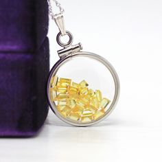 "Vibrant handcrafted brand new sterling silver genuine yellow sapphire shaker locket! This radiant pendant is dime sized with coin style bezels, and clear lucite covers. The round charm showcases genuine fancy sapphires in bright yellow hues. There is an estimated 2.5 CTW of faceted baguette cut sapphires sparkling within the double sided locket's clear lucite covers. A gorgeous piece of brand new gemstone jewelry, featuring beautiful genuine gems! ERA - New METAL / MATERIAL - Sterling silver lo Amber Sterling Silver Round Pendant Jewelry, Yellow Polished Round Pendant Jewelry, Round White Gold Jewelry With Yellow Sapphire, Fine Jewelry: Silver Yellow Sapphire, Sterling Silver Yellow Charms Jewelry, Fine Jewelry Silver Yellow Sapphire Jewelry, Yellow Sterling Silver Charms Jewelry, Yellow Polished Pendant Jewelry, Yellow Pendant Jewelry With Polished Finish