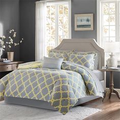 a bedroom with gray walls and yellow bedding