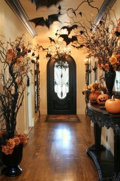 an entry way decorated for halloween with pumpkins and branches