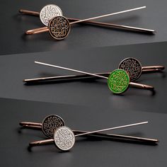 four different types of hair pins with arabic writing on the top one is green and silver