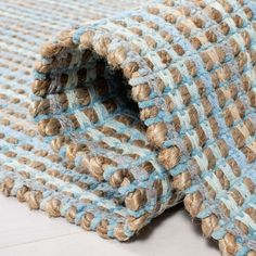 a blue and brown rug is laying on top of a white floor with an open hole in the middle