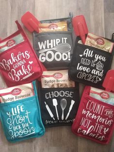 six reusable oven mitts with sayings on them sitting on the floor