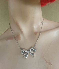 bow necklace sterling silver (925) Beautiful large piece Attached chain..please convo me to see what chain is available at purchase.. The bow is 35 mm x 27 mm (1 1/2 '' x 1 '') Her total weights is 12gms Her total length is 42 cm ( 16 1/2 '') The chain is soldered to the bow.. And yes it I can adjust ..shorter if you prefer The chain in the photo us sold..but I can make this pendant on any chain ..also looks beautiful in gold Has a matching now ring also Vintage Ribbon Necklaces For Party, Vintage Ribbon Necklace For Gift, Silver Bow Jewelry For Evening, Silver Bow Necklace For Wedding, Silver Sterling Silver Necklace With Bow, Silver Jewelry With Ribbon For Party, Silver Victorian Necklace For Party, Retro Silver Necklace For Evening, Formal Sterling Silver Ribbon Jewelry