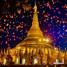 there are many lanterns flying in the sky above this building and it looks like they have been lit up