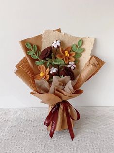 a bouquet of flowers sitting on top of a white tablecloth covered table next to a wall