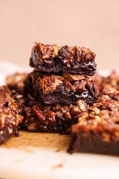 chocolate brownies stacked on top of each other with pecans in the middle and one cut in half