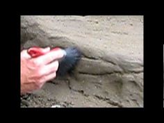 a person is digging in the sand with a tool