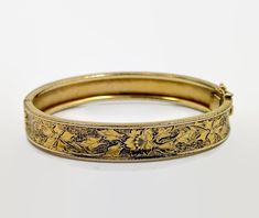 I love this bracelet both in style and condition! This is a Victorian Revival, hinged bangle from the. 1930's - 40's. It is 12K gold filled in wonderful. This has a beautiful etched and textured pattern to it. It features a floral pattern.  The background has a texture to make the flower stand out. It features a slide clasp is in perfect working order with an attached safety latch for extra protection. Beautiful piece on it's own or stack it with more for a statement look. Condition: Very good vintage condition, vintage patina - Only spot that might have wear is right at the clasp, but that might be tarnish; condition consistent with age Measurements: 0.43" or 10.71 mm wide; inside measurement 7" around Weight: 17.2 grams Markings: 1/20 12KTGF and what looks like 3 initials that I cannot m Victorian Bracelet, Armband Gold, Victorian Revival, Vintage Fans, Flower Stand, Vintage Bracelet, Hinged Bangle, Bracelet Gold, Arm Band