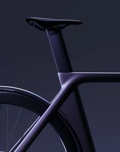 the front end of a bike with black spokes and seatpost, against a dark background