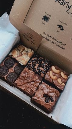 a box filled with brownies covered in chocolate and nuts