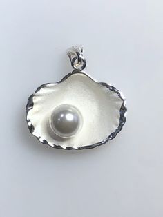 "Sterling Silver shell with simulated pearl  Made in Thailand 925 marked Height 1 1/8\" with bail, Width  1\"" Elegant Shell With Pearl Charm, Elegant White Shell With Pearl Pendant, Elegant Pearl White Shell With Pearl Charm, Elegant Pearl Drop Shell, Elegant White Shell Pendant, Elegant Silver Pendant Shell, Elegant Round Shell As Gift, Elegant Shell Gift, Elegant Round Shell Gift