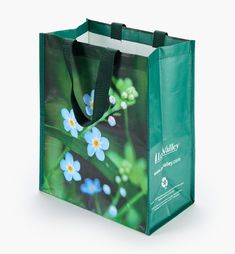 a green shopping bag with blue flowers on it