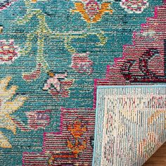 two rugs with different colors and patterns on the floor in front of a wooden surface