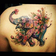 an elephant with flowers on it's back is painted in watercolors and ink