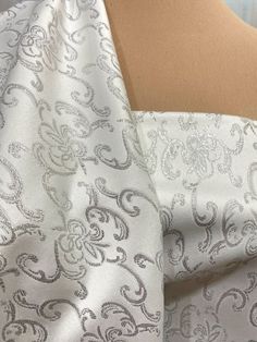 Satin Brocade White/SilverJust beautiful !!I can see jackets, dresses, drapes, pillows, chair cushionsformal wear, bridal gowns.  multiple yards purchased for this listingwill be continuous cuts of yardage.    *      Width: "56 " wide     * Length per listing: 1 yard    * Price per yard is $19.99    * Type: Satin Brocade    * Weight: 15 oz's    * Content:  85% acetate/15% metallic     * Care: dry clean Elegant Cream Fabric For Party, Cream Elegant Party Fabric, Satin Gown, Brocade Fabric, Bustiers, Corsets, White Silver, Formal Wear, Bridal Gowns