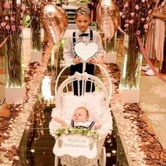 a baby in a stroller with balloons and streamers behind it that say i love you