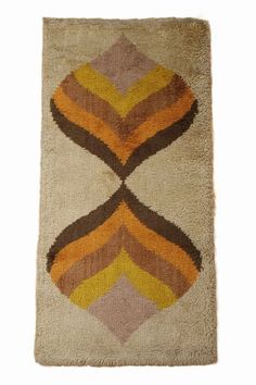 a rug with an orange, brown and yellow design on the bottom half of it