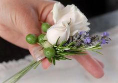 a person holding flowers in their hand on a white furnishing area with purple and green accents