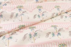 a pink and white striped fabric with horses on it