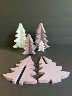 three small wooden christmas trees sitting on top of a table