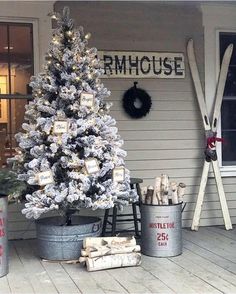 a white christmas tree sitting on top of a wooden floor next to two buckets