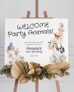 an animal themed birthday party sign with balloons and flowers on it, sitting in front of a wooden easel