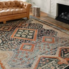 a living room filled with furniture and a rug on top of a hard wood floor