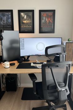 a computer desk with two monitors and a printer on it in front of some pictures