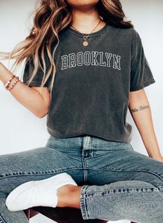 Brooklyn T-shirt, New York College Style Tee, Brooklyn Souvenir. 100% Cotton, Authentic COMFORT COLORS T-Shirt, Premium Quality Fabric, Printed in the USA Direct on Garment Printing using Water Based Eco-friendly Inks. Unisex Sizing, Relaxed Fit For Women.  Go 1-2 sizes up for the oversized look On White and Ivory colors we print black text. You can compare one of your tees to the sizing chart available in our listing photos. Colors might be look a bit different on different screens, the design Trendy Gray T-shirt With Text Print, Everyday Crew Neck T-shirt With Screen Print, Gray Crew Neck T-shirt For College, Relaxed Fit Crew Neck Tops With Text Print, Casual Text Print T-shirt For College, Relaxed Fit Crew Neck Top With Letter Print, Gray Urban T-shirt For Everyday, Urban Gray T-shirt For Everyday, College Style Relaxed Fit Short Sleeve T-shirt