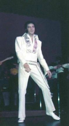 elvis presley performing on stage in white suit