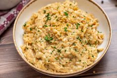 a white bowl filled with macaroni and cheese on top of a wooden table