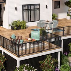 a deck with chairs and tables in front of a house