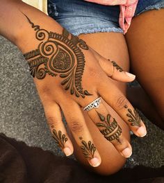 a woman's hand with henna tattoos on it