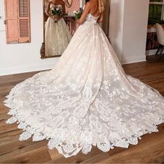 a woman in a wedding dress looking at herself in the mirror