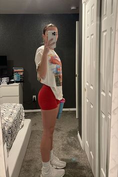 Girl taking a mirror selfie wearing an oversized thrifted shirt, red biker shorts, tall socks, Adidas ultra boosts, and a slick back bun. Leg Day Outfit, Ultra Boosts, Slick Back Bun, Outfit Fitness, Outfit Adidas, Running Outfit, Outfit Oversize, Estilo Fitness