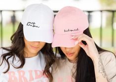 two women wearing matching hats with the same name on them