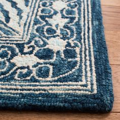 a blue and white rug on the floor with an intricate design in the middle,