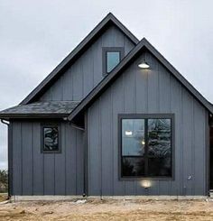 a gray house sitting on top of a dry grass field