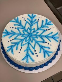 a white cake with blue frosting on top of a counter next to an oven