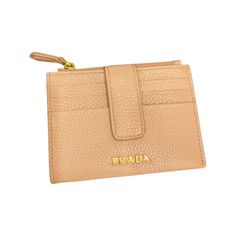 This light beige Prada wallet is an effortlessly chic way to store credit cards, coins, and small bills. This wallet's conveniently small size makes it easy to keep in your purse or pocket. The four exterior card slots makes organizing a breeze.    Model: 1MC026  Cipria Beige Leather    Gold Tone Hardware  Prada Milano Logo  Zipper Closure  Four Exterior Card Slots  Vitello Grain Pebbled Leather  Measurements: 4.5 x 0.75 x 3.5" (LWH)  Includes authenticity cards and Box  Made in Italy Prada Milano, Prada Wallet, Leather Card Wallet, Mini Wallet, Fold Wallet, Mini Purse, Zip Wallet, Carry All Bag, Wallet Chain