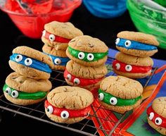 some cookies with eyes are sitting on a cooling rack in front of other food items