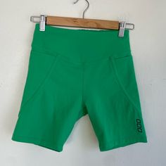 green shorts hanging on a white wall