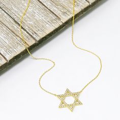 Embrace tradition, elegance, and faith with our Star of David Necklace. Whether for yourself or as a cherished gift, this necklace is a symbol that endures through time, offering a connection to your beliefs and a touch of beauty to your style.✨ Finish: White Gold Dipped or Gold Dipped Adjustable Chain 15.5 to 17.5 inches The Star Pendant is 1 in.*1 in. This necklace is ready to ship in 1 - 2 business days To ensure lasting beauty and shine, follow these simple care instructions: * Avoid Contact Elegant Everyday Star Of David Necklace, Yellow Gold Star Of David Necklace With Delicate Chain, Celestial Gold Star Of David Necklaces, Gold Star Of David Necklaces, 14k Gold Star Of David Necklace, Tarnish Resistant, Jewish Star Necklace, Star Of David Necklace, Jewish Star, Necklace Star